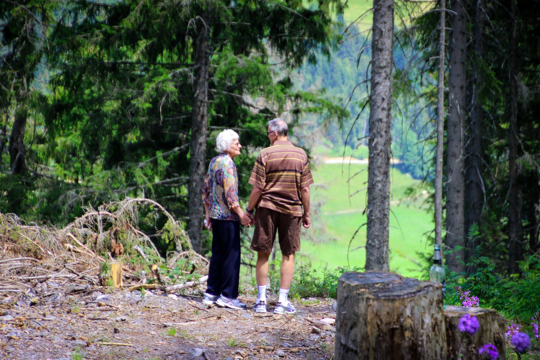 two people standing in forest